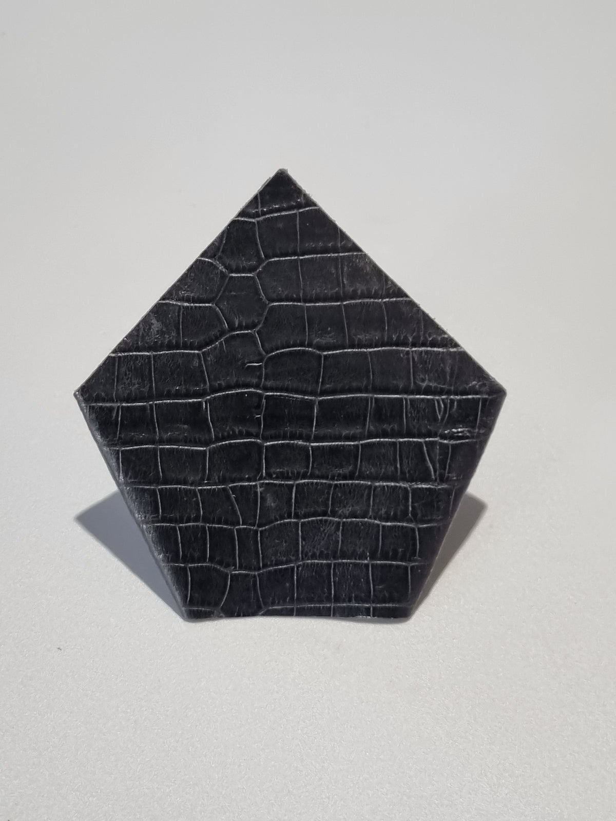 A black leather men attire suit square pocket made from real leather embossed with crocodile print. Leather accessory item shown on a plain light gray background.