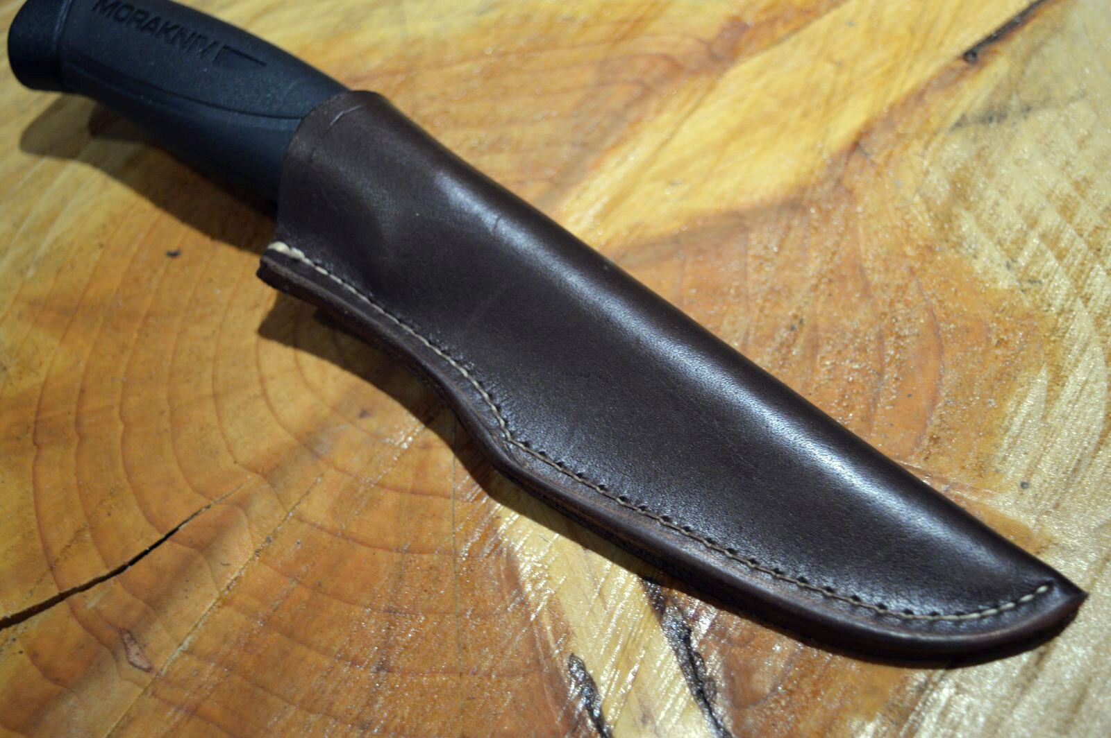 A black leather sheath for a Morakniv 860 type knife, with a black handle visible at the top.