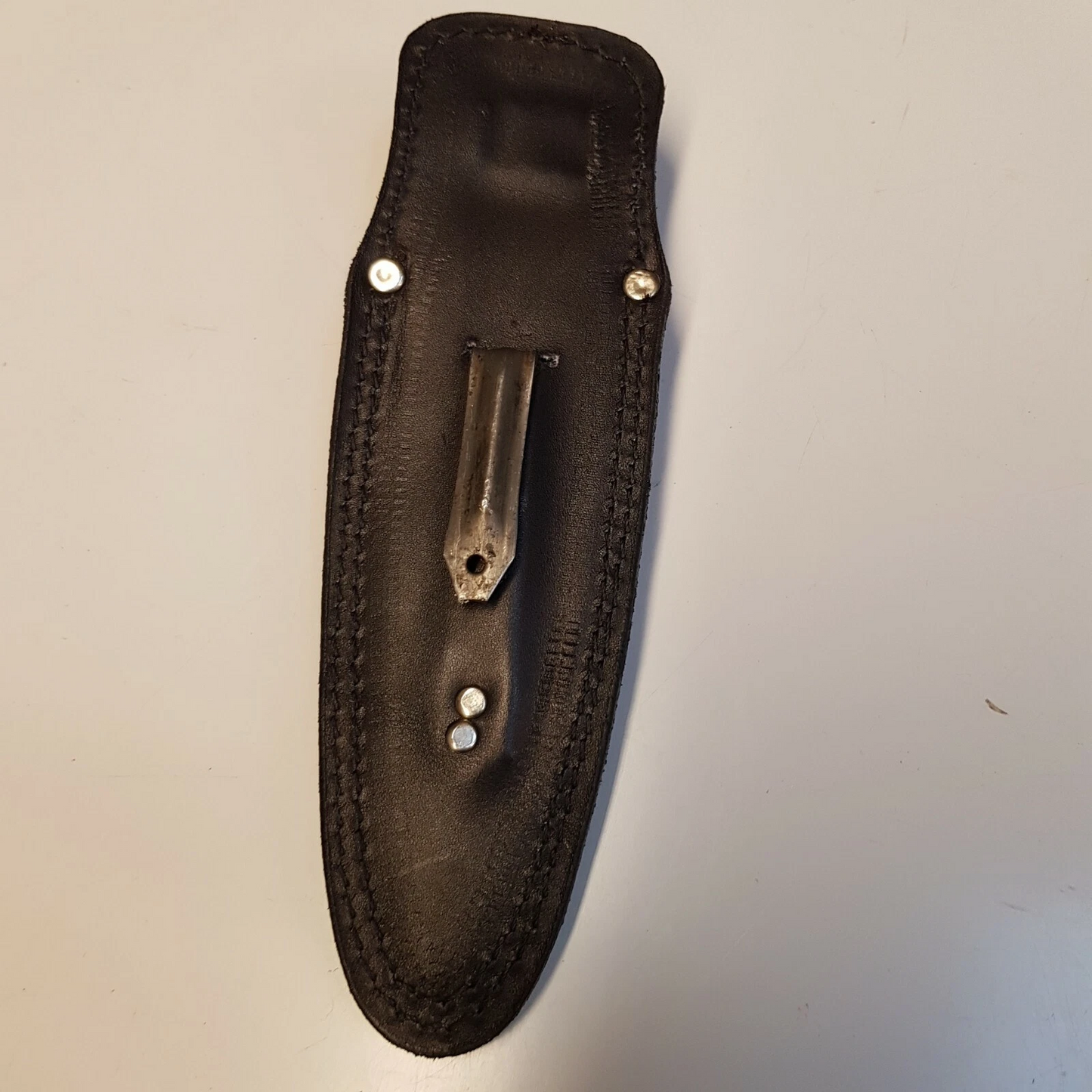 Full view of black leather Pentagon SOG sheath showing back of the sheath with metal  boot clip on white background 