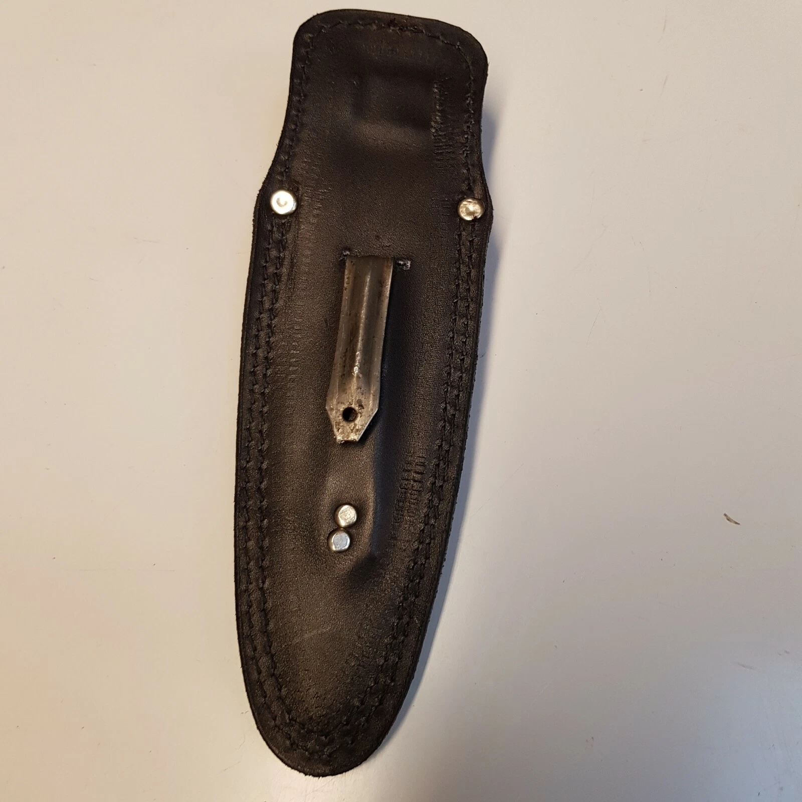 Full view of black leather Pentagon SOG sheath showing back of the sheath with metal  boot clip on white background 