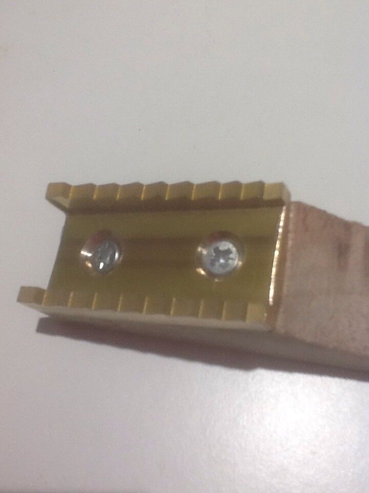 A close-up of a pure brass welt mill with a wooden base, showing the brass steps and the groove for securing the welt.
