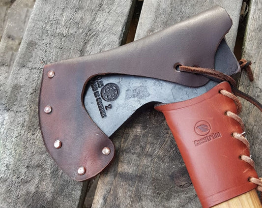 axe head and handle leather guard on wooden background