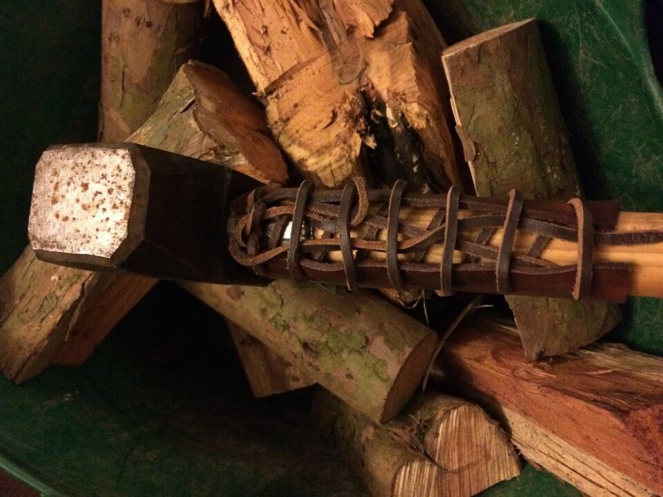 axe handle guard laced on an axe shown on wooden logs background