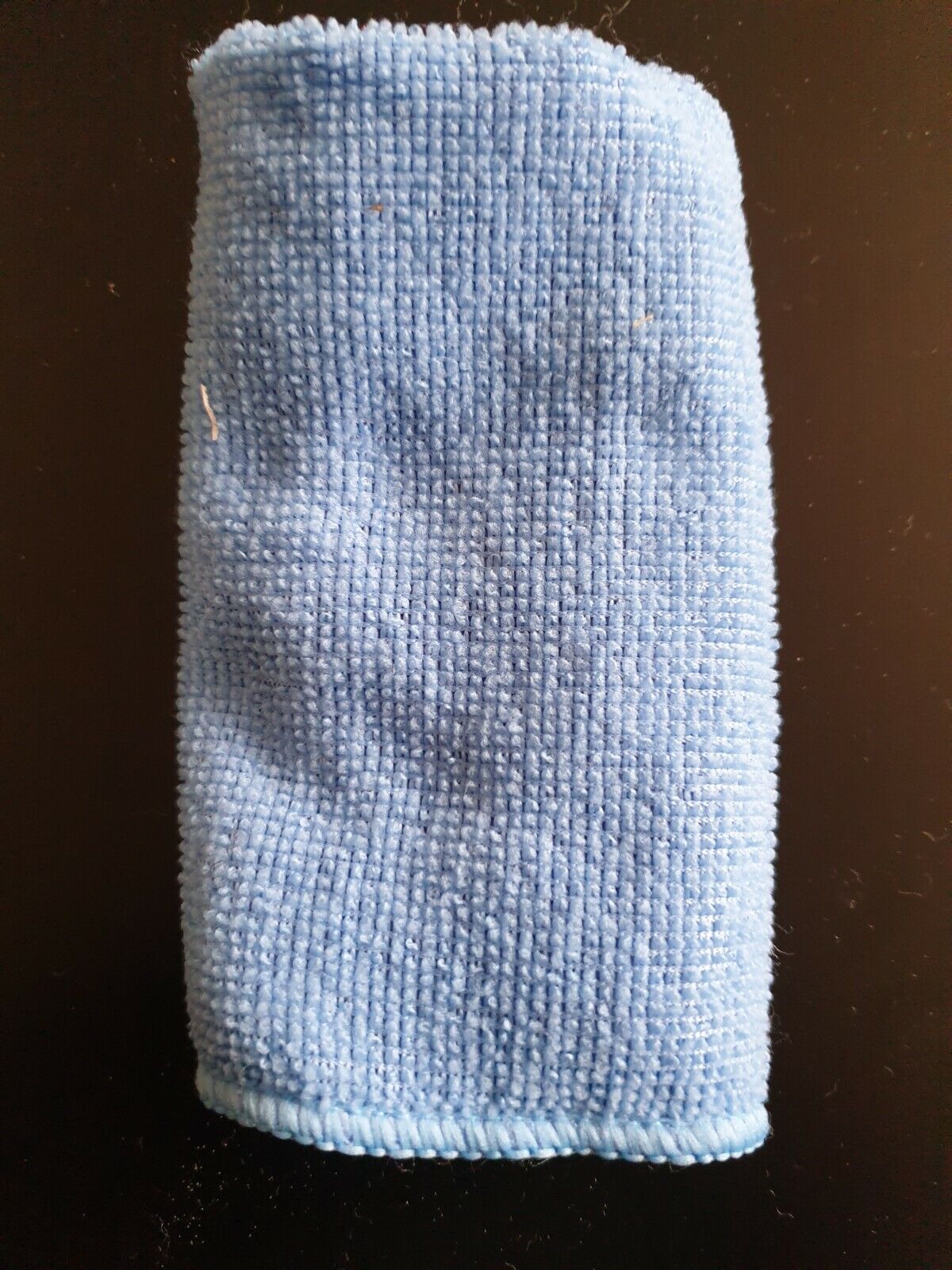 blue micro fibre cloth set against dark background