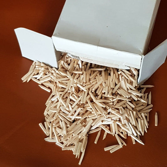 A box of birch wood wooden nails or pegs spilled open, revealing several light-coloured wooden pieces.