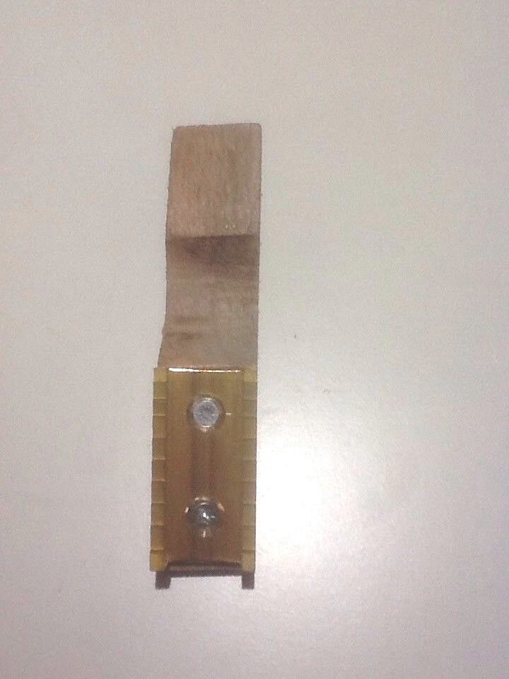 A close-up of upright pure brass welt mill with a wooden base, showing the brass steps and the groove for securing the welt.