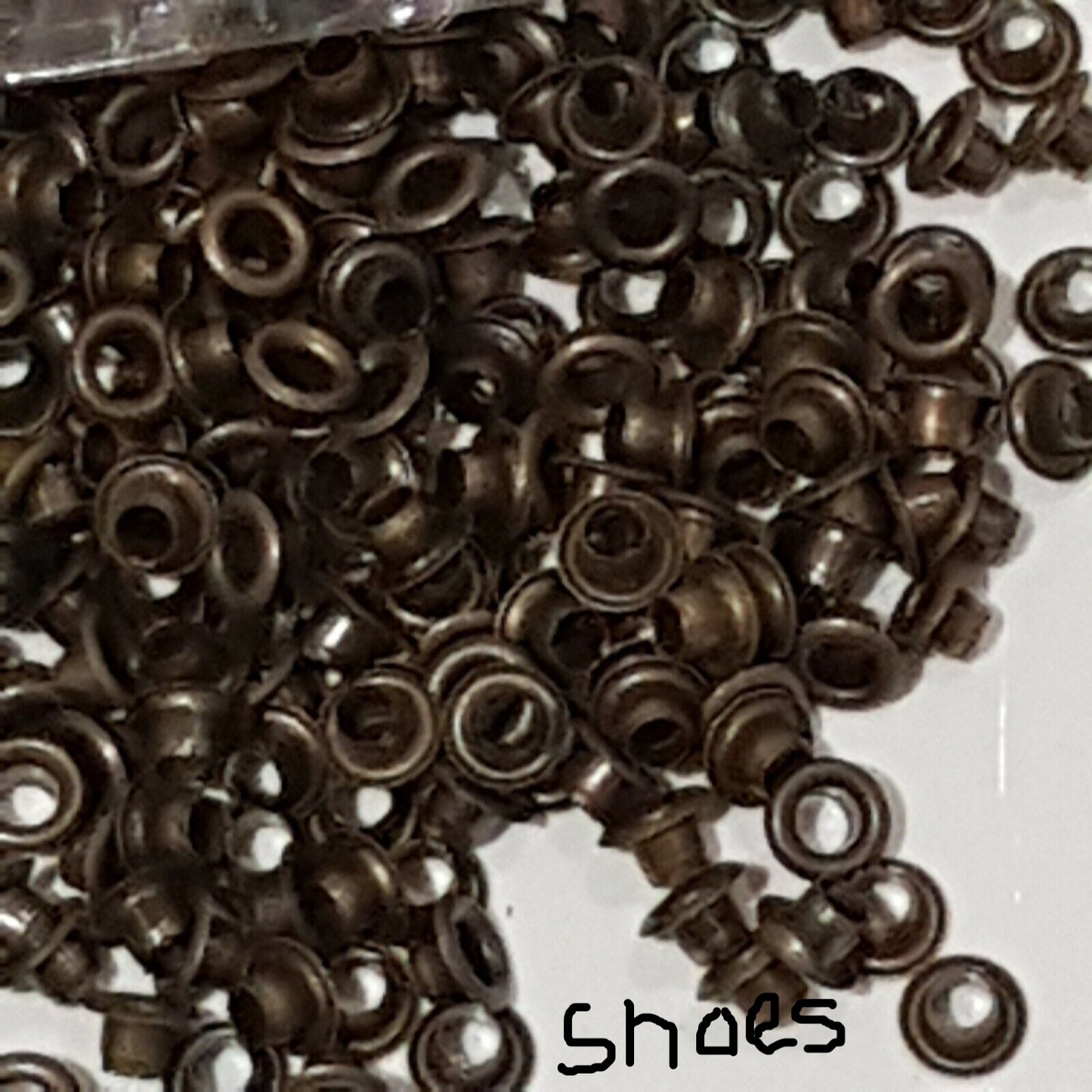 close view of brass finish shoe eyelets in a heap