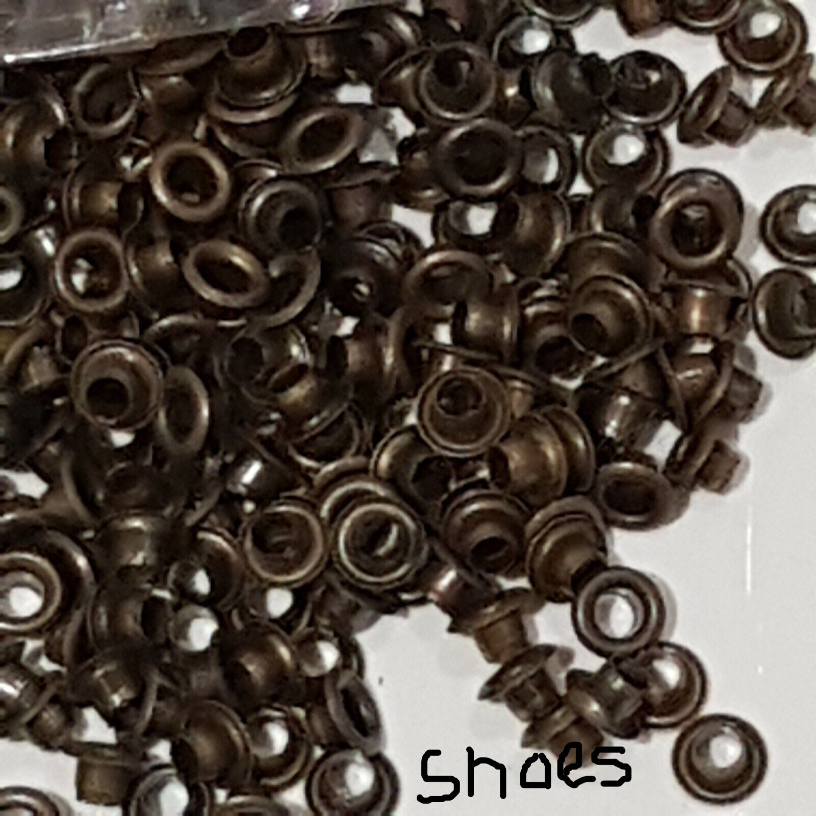 close view of brass finish shoe eyelets in a heap