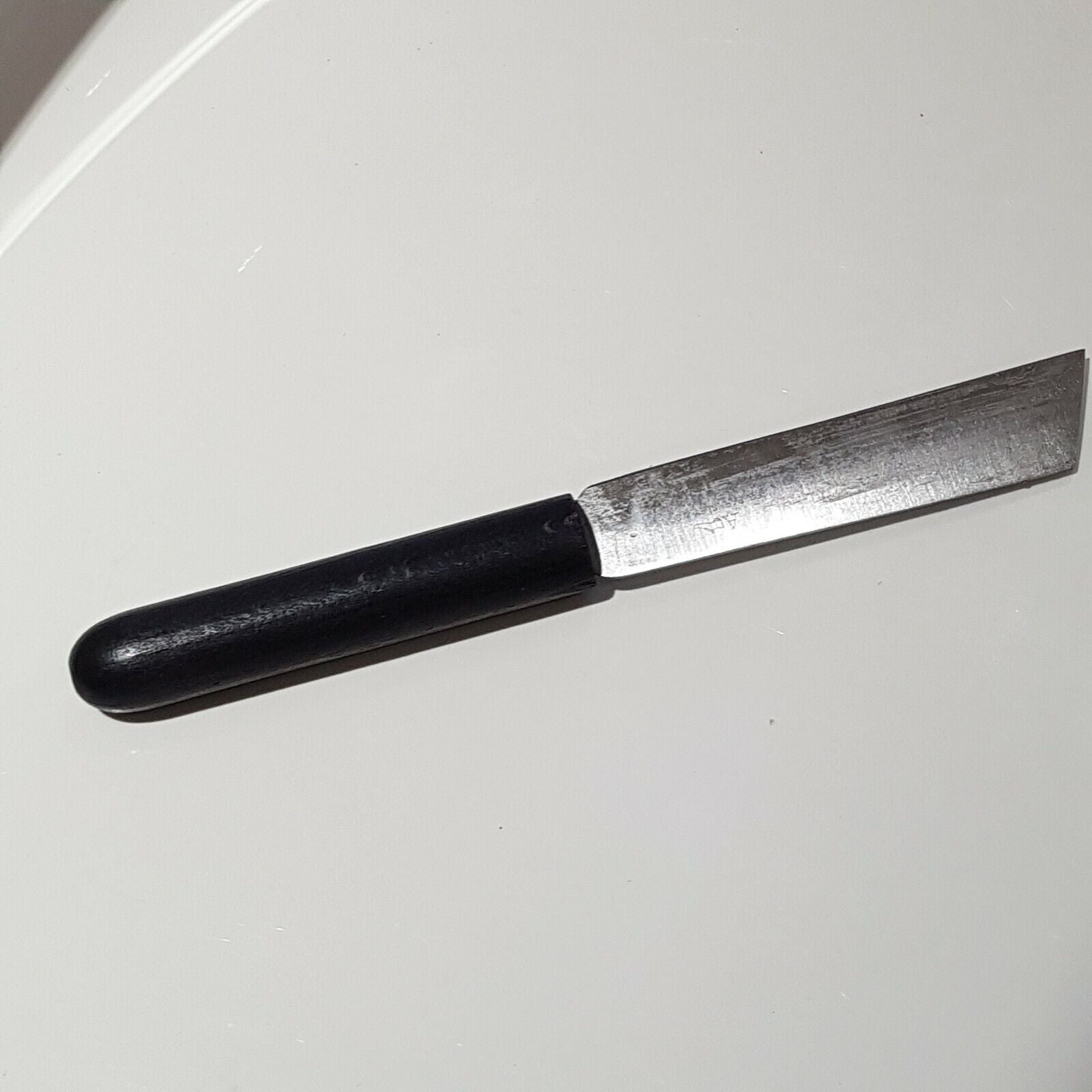 Full view of broad point heel parring knife of white background