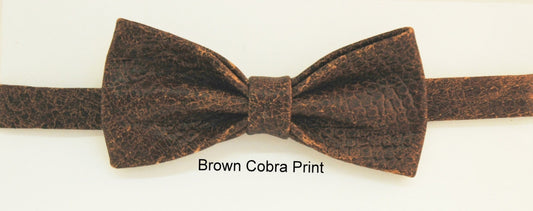 A brown cobra snakeskin printed leather bow tie displayed against a neutral background.