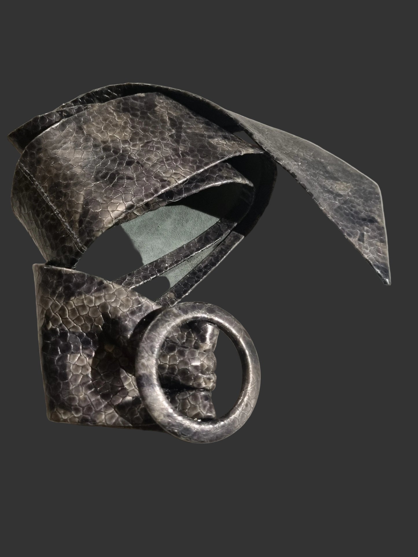 Shades of grey cobra snakeskin embossed women leather cinch belt with a hammered scales and large leather covered buckle, shown folded on a light gray background.