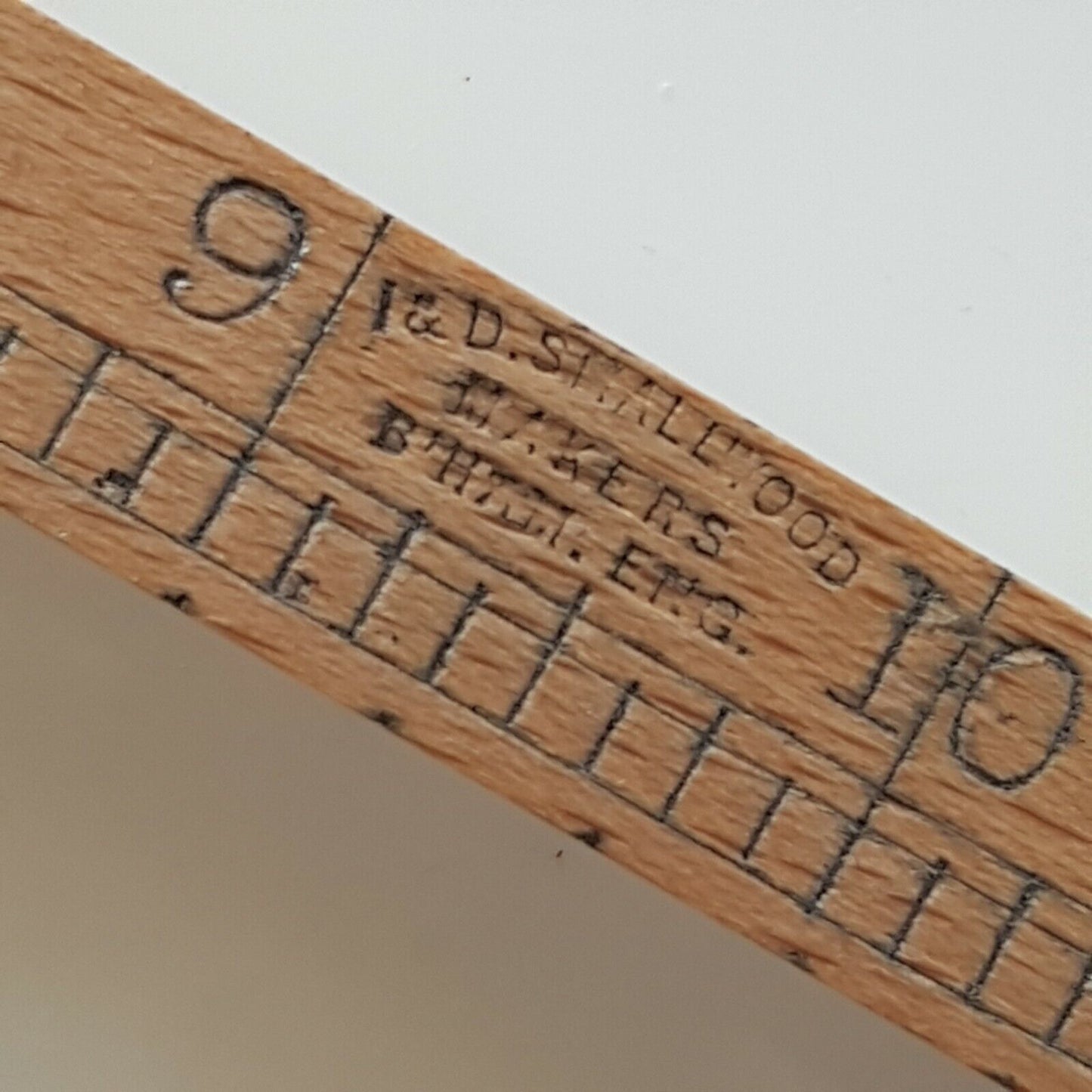 A close view of cloggers shoe size stick with makers name I & D Smallwood makers Birmingham England place on a white surface.
