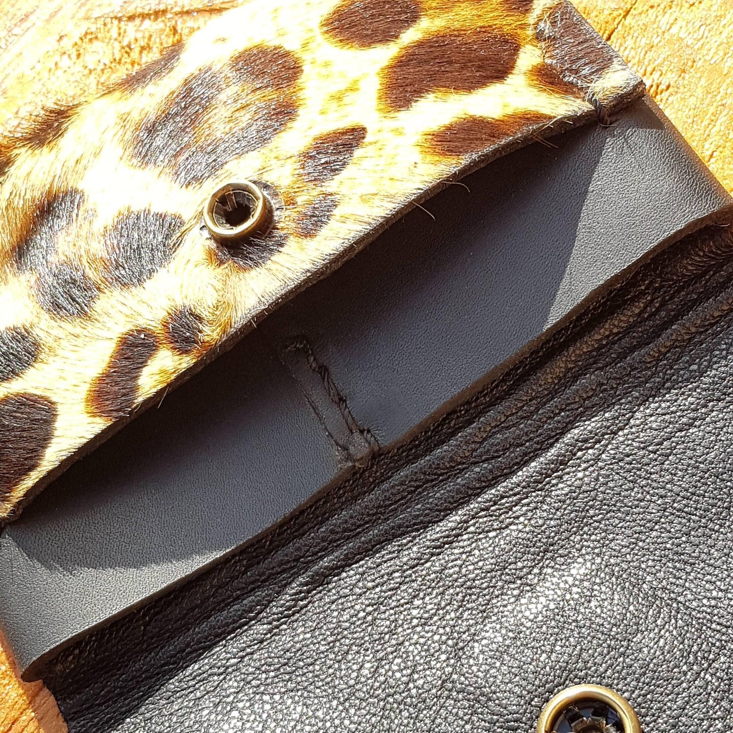 Close up view of leopard print hair-on leather wallet pockets plus snaps