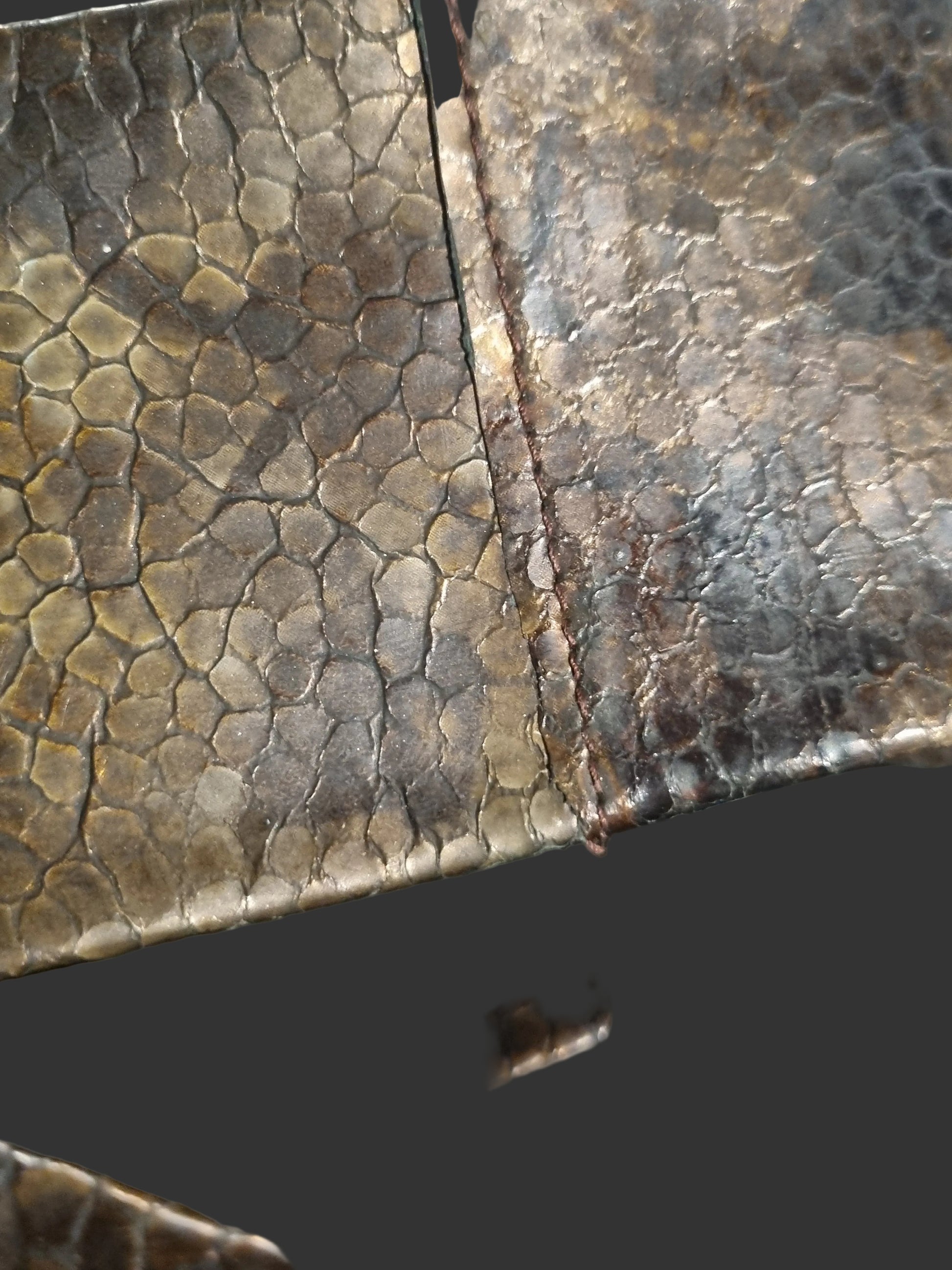 Close-up of a copper bronze cobra snakeskin women waist leather belt showing seam stitching