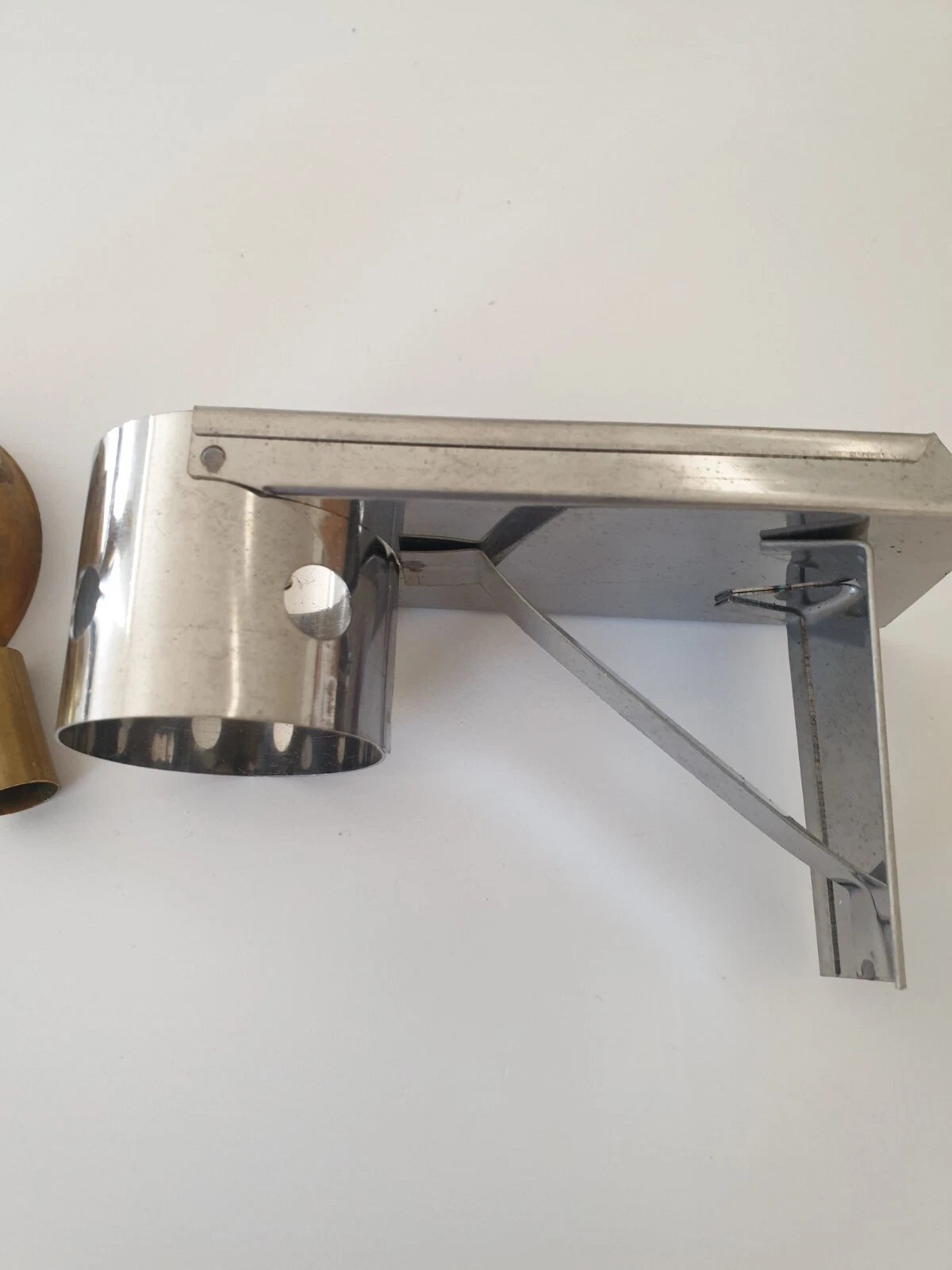 A brushed stainless steel stand mounted on cylindrical mount and  support arm, shown against a plain white wall.