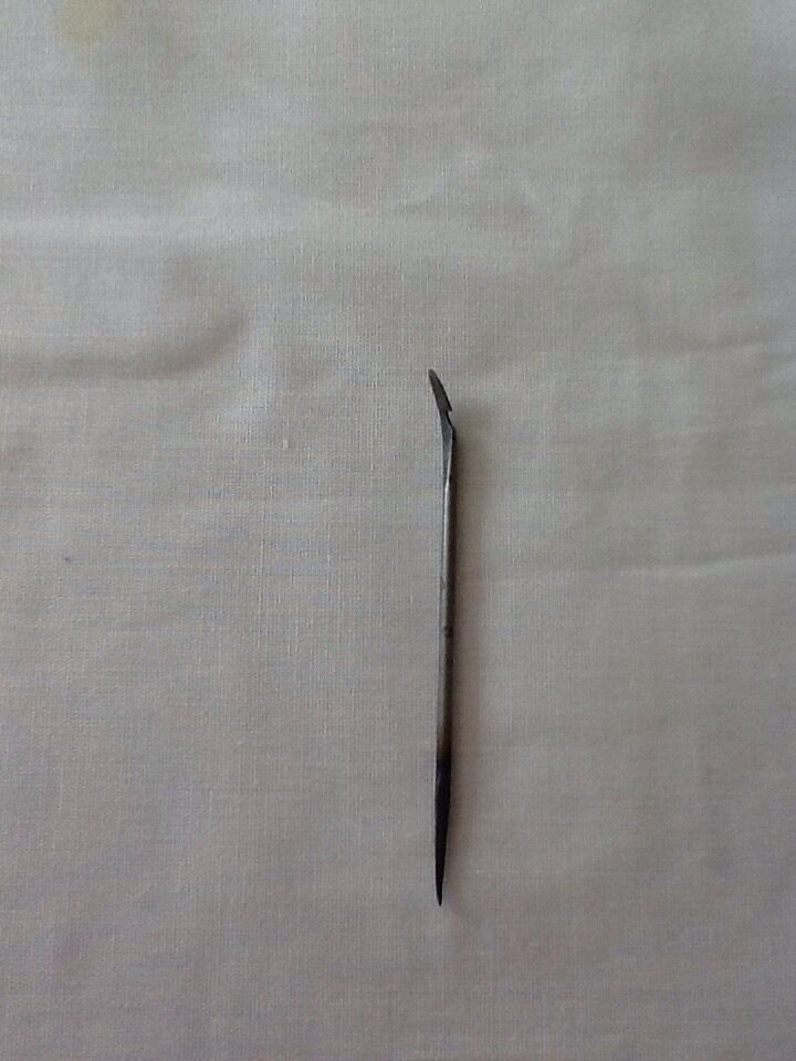 A single curved hooked awl blade made of cast steel show upright, placed on a light background.