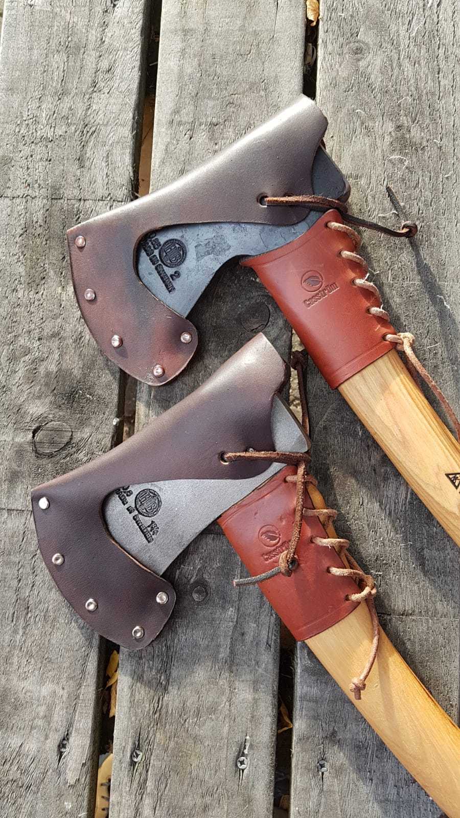 double axe head and handle leather guards on a wooden background