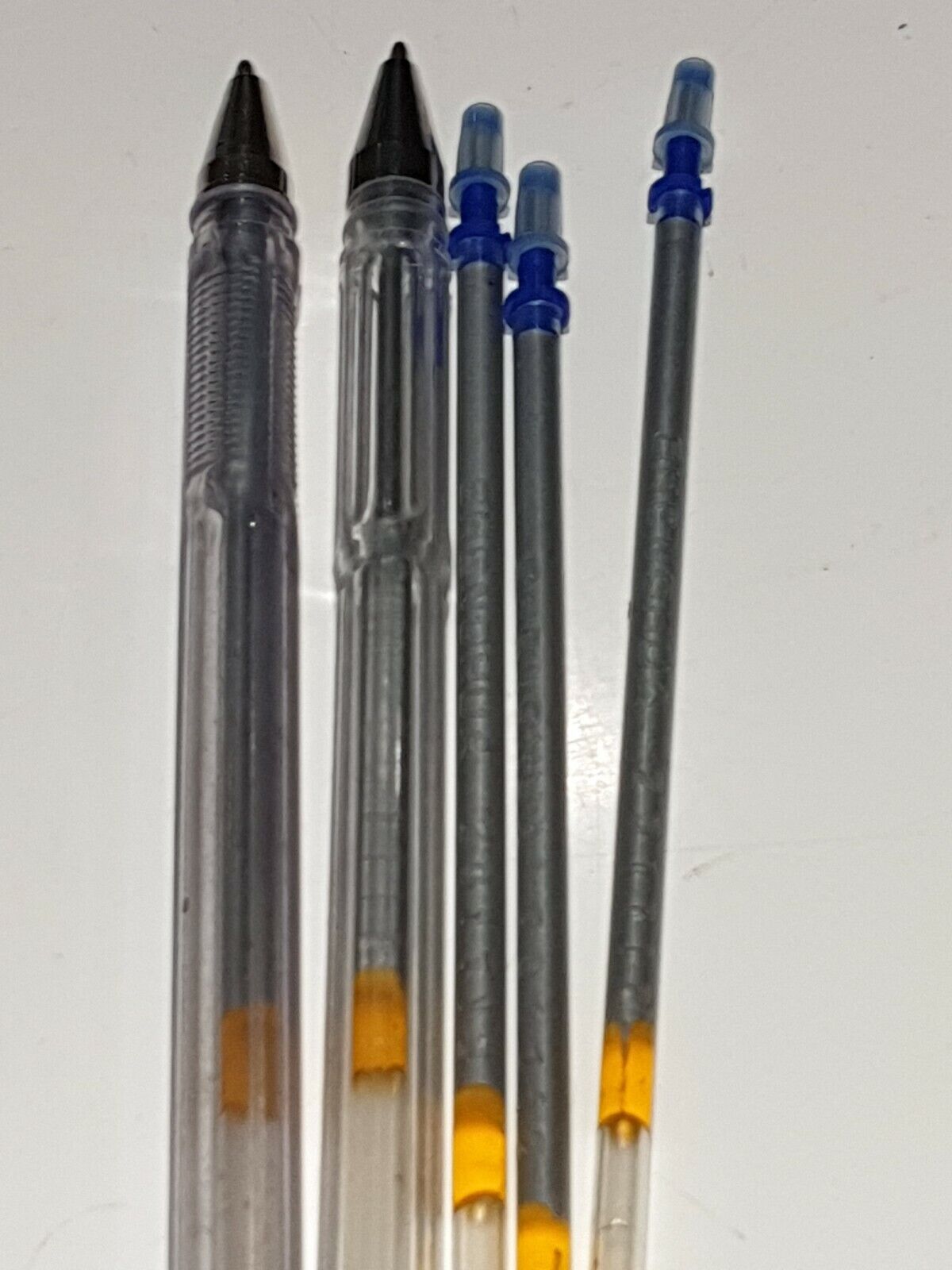 A set of four silver leather marking pens with refills, three with blue caps and one with a gray cap.