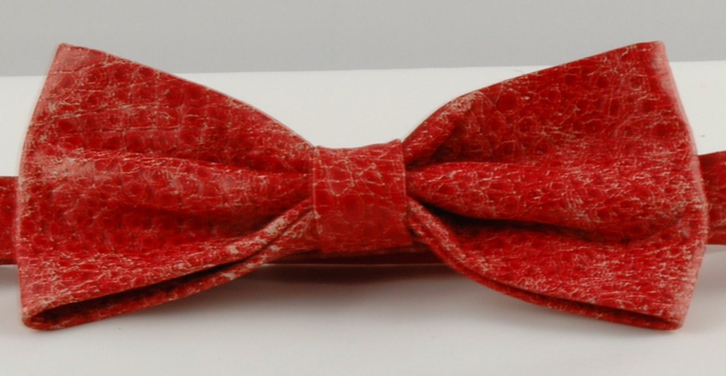 A pink cobra snakeskin printed leather bow tie displayed against a neutral background.