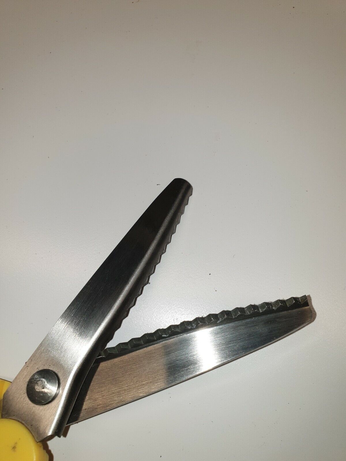 Close view of blades of pinking gimping scissors made of stainless steel, designed for leathercraft work.