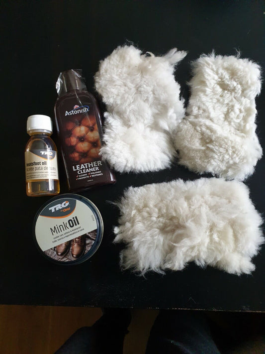 A kit containing a small bottle of  Neat foot oil, bottle of leather cleaner, tin of mink oil and three woollen pads  arranged on a dark background