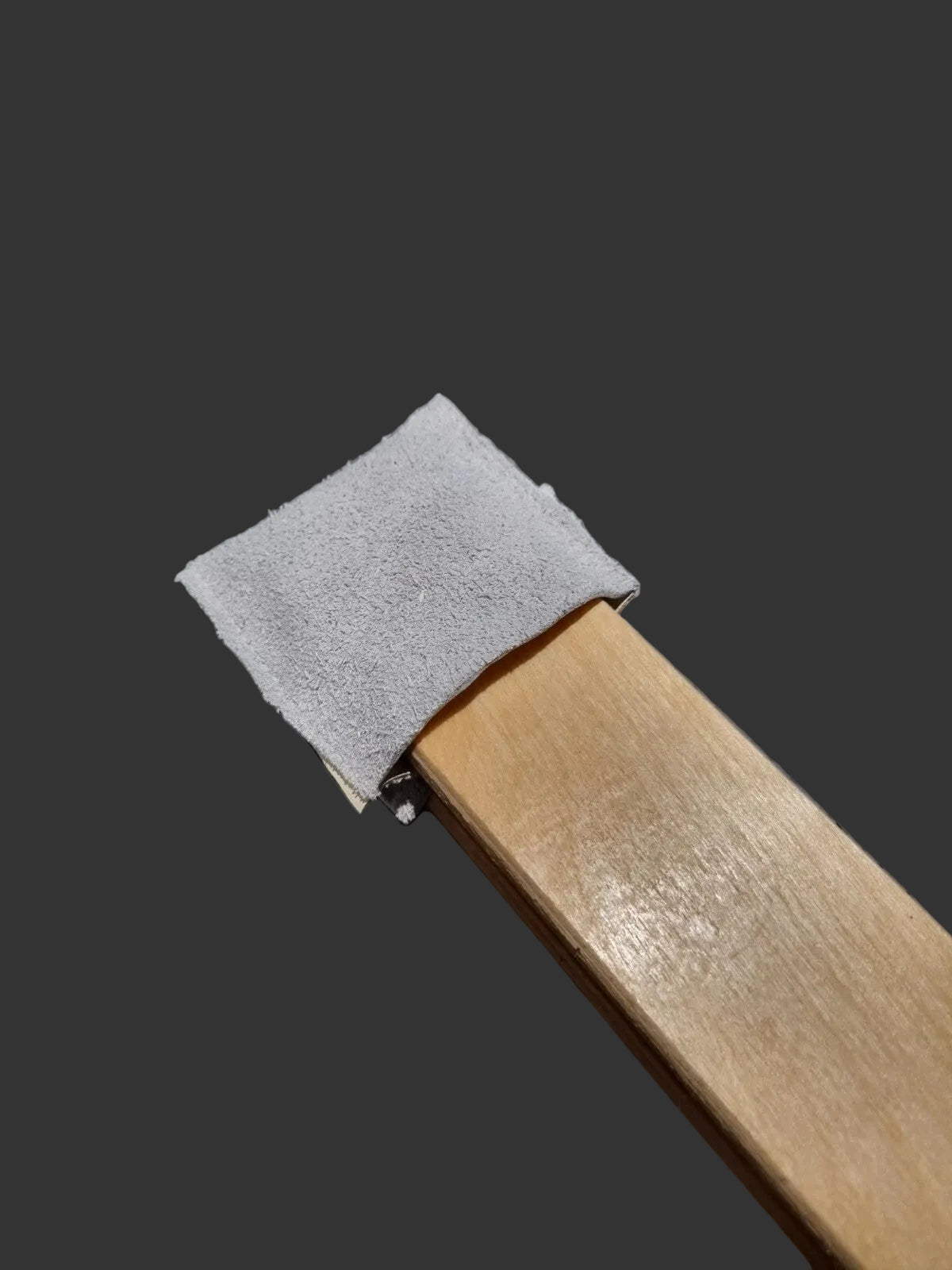 A close-up of a wooden clam jaws wrapped with a light grey leather socks 