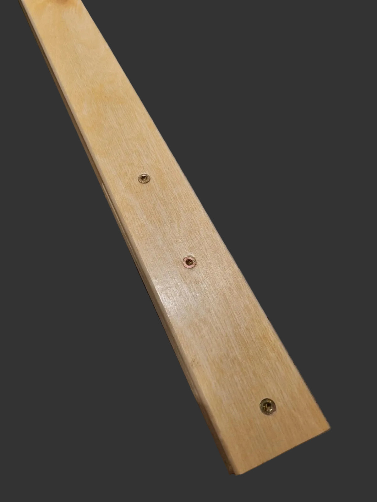 A long hand stitching clam made from birch wood showing wooden slat with three pre-drilled screw holes