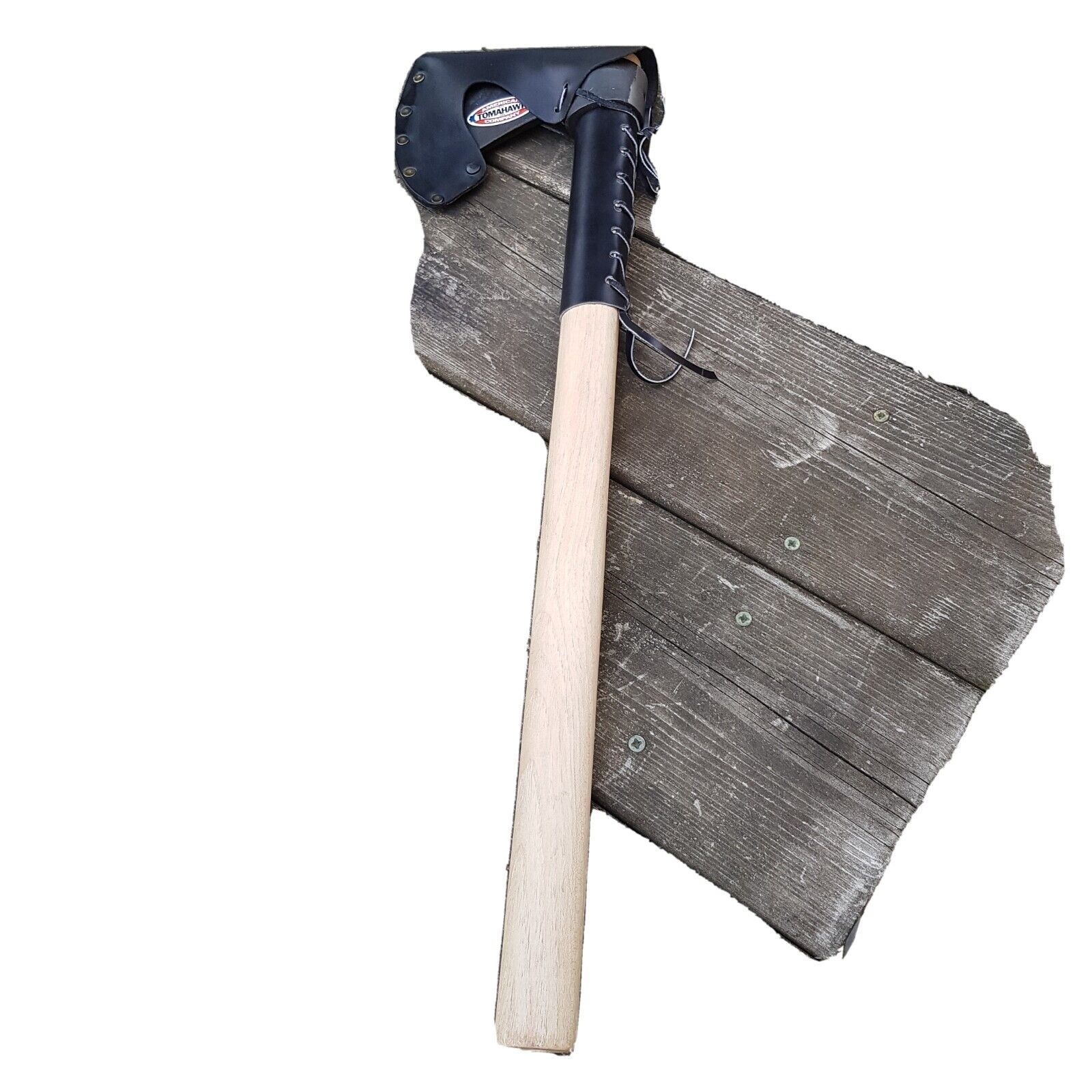 Tomahawk axe with wooden handle leather protector and axe head leather sheath displayed on a wooden surface.