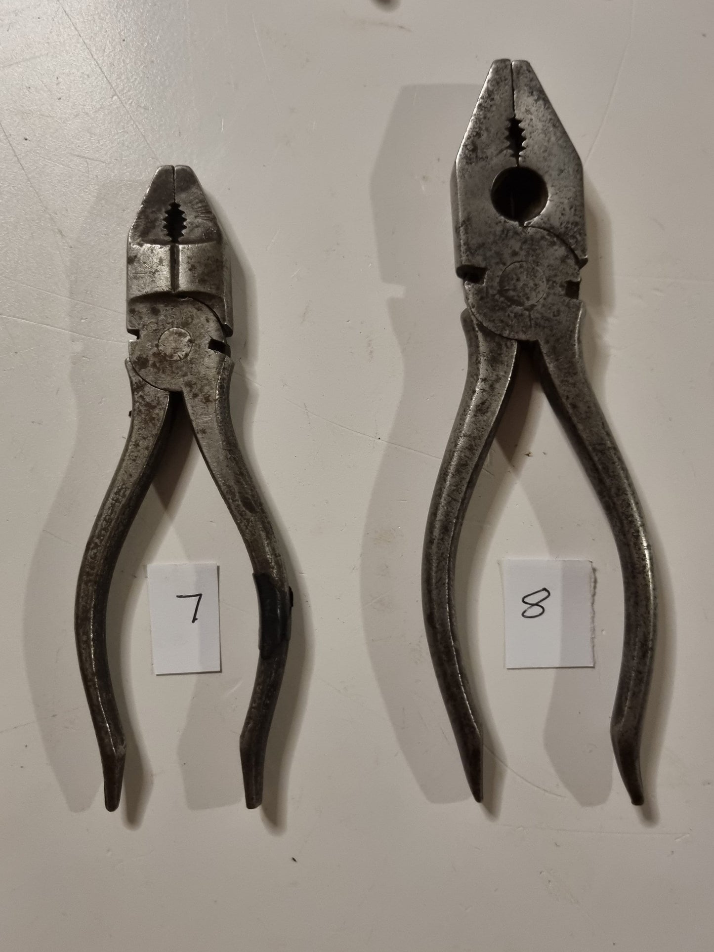 close view of vintage metal pliers titles 7 and 8 on white background
