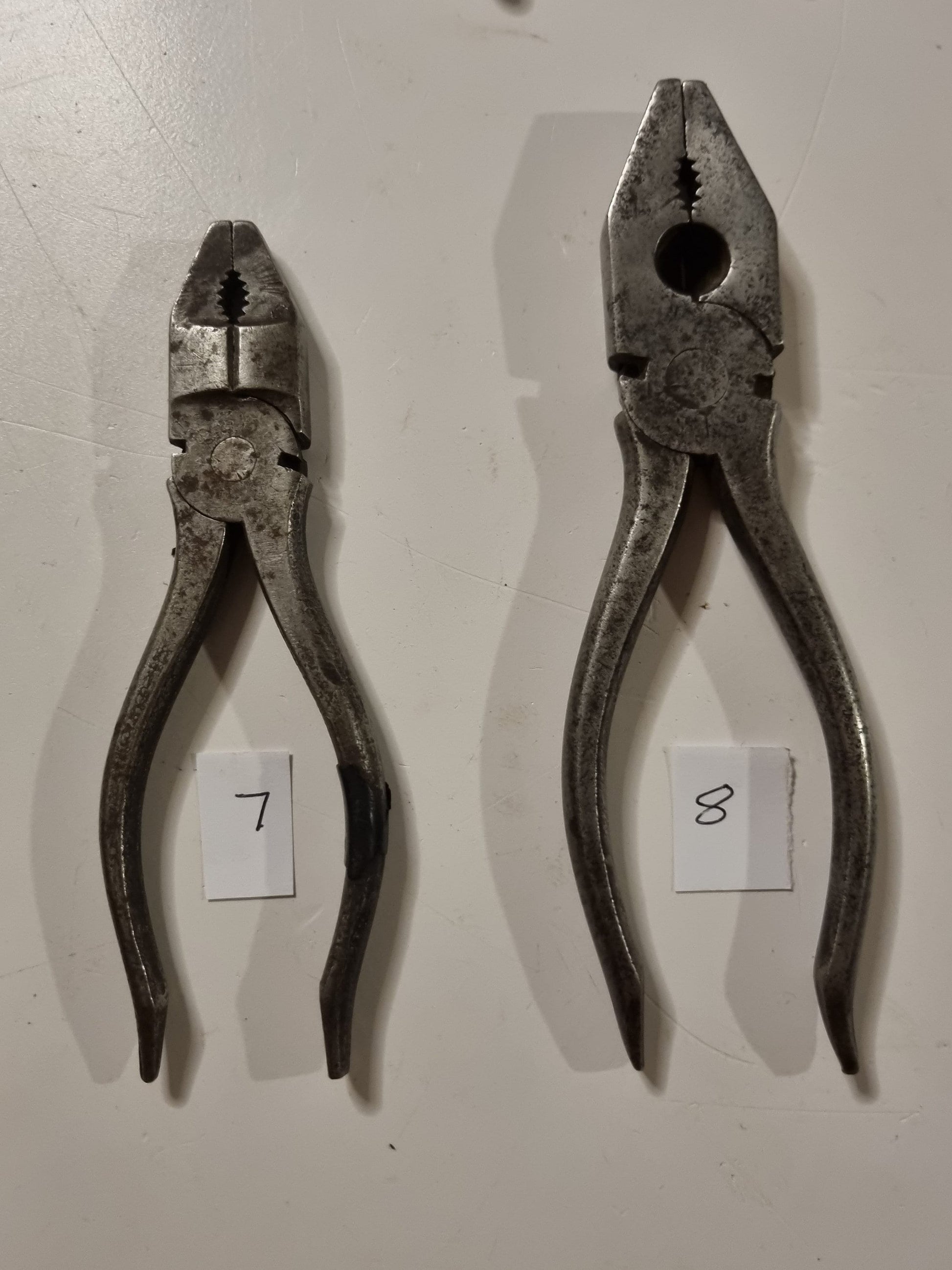 close view of vintage metal pliers titles 7 and 8 on white background