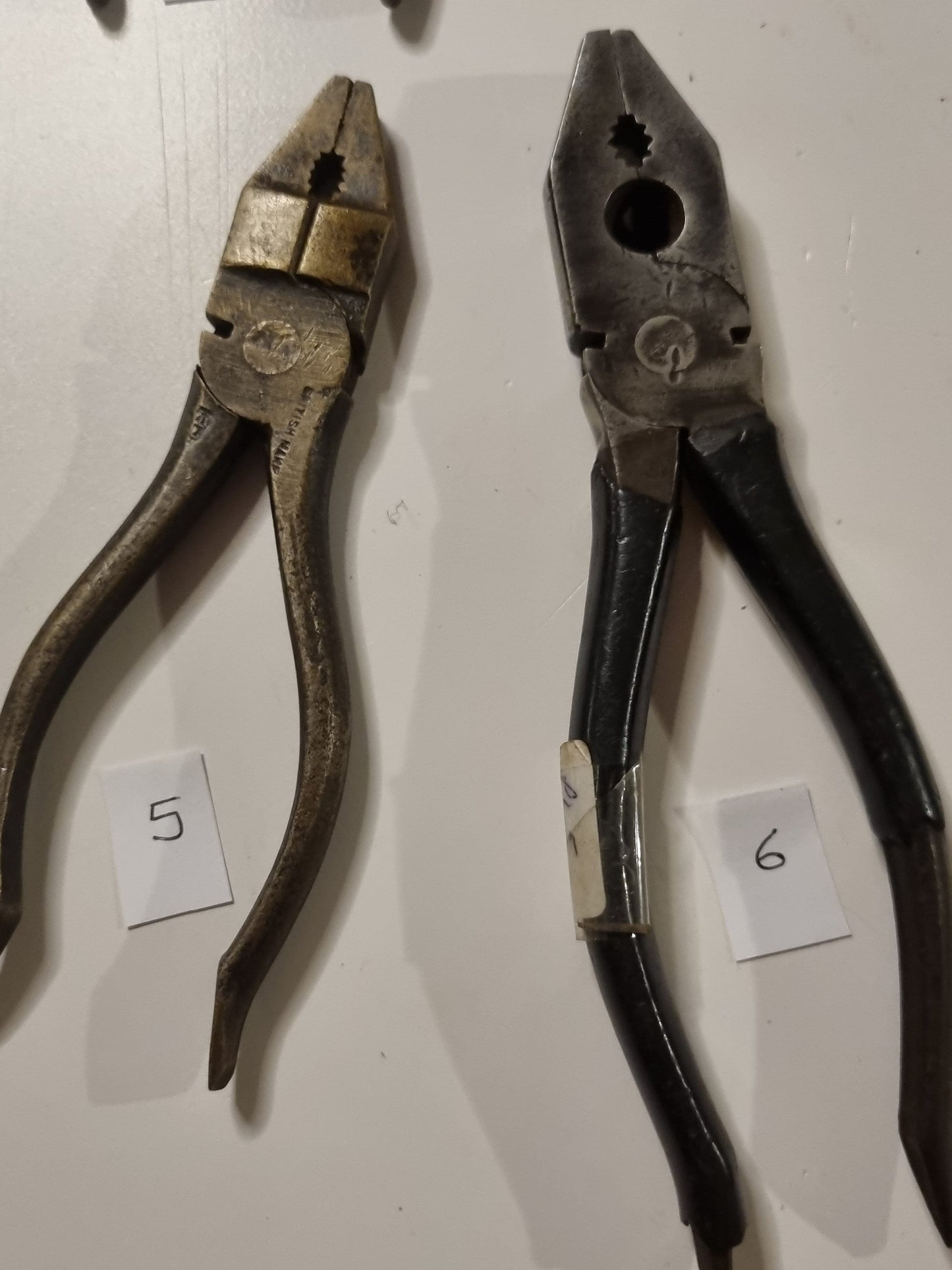 close view of vintage metal pliers titles 5 and 6 on white background