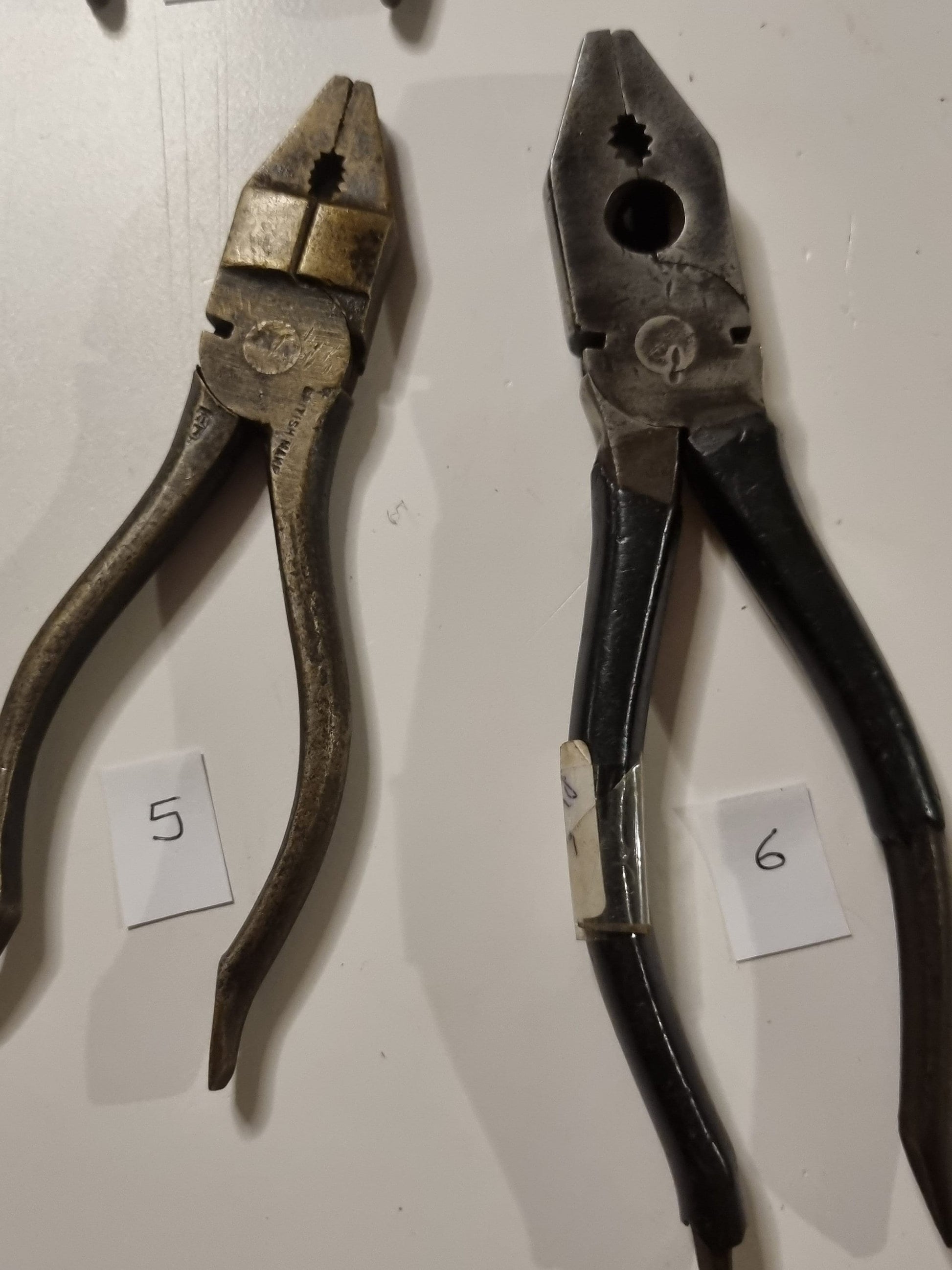 close view of vintage metal pliers titles 5 and 6 on white background