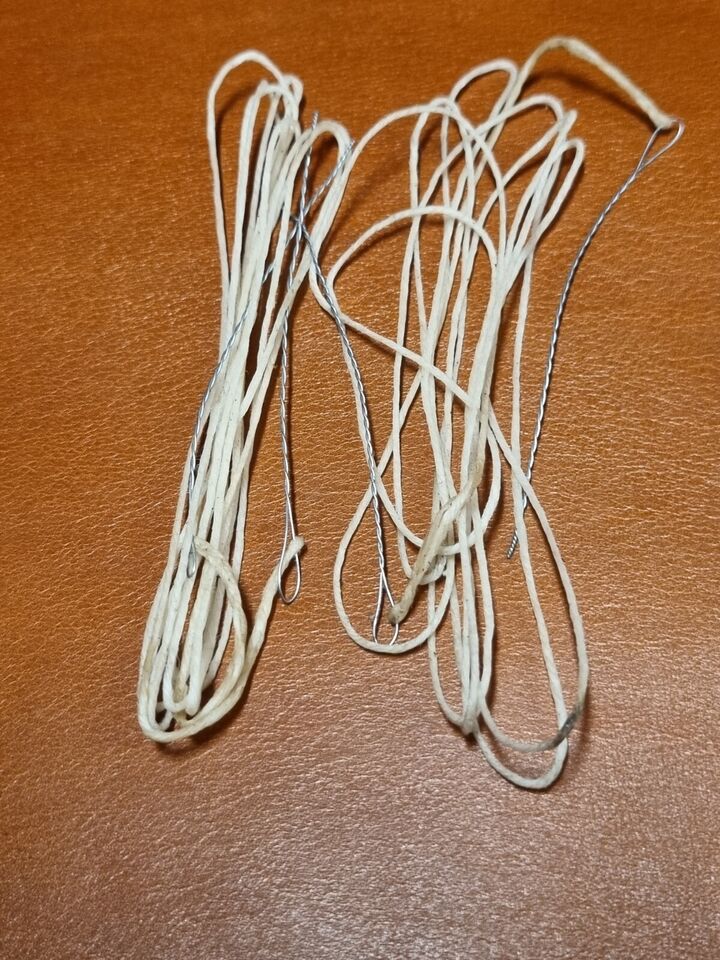 Close view of handmade pair of wire bristle attached to waxed threads for hand stitching